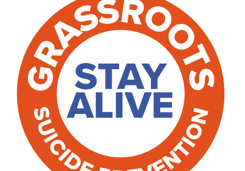 Red circle with the words 'GRASSROOTS SUICIDE PREVENTION' written around the circle. 'STAY ALIVE' is written inside the circle in blue.